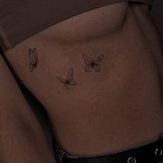 a woman's stomach with three butterflies on her side and the bottom part of her body