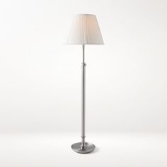 a floor lamp with a white shade on it