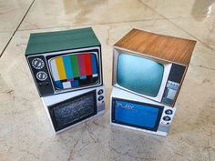 two cardboard tvs sitting next to each other on a table