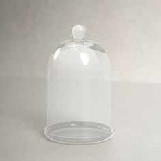 a clear glass clochel with a white background