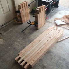 two pieces of wood sitting on top of a floor next to a machine and tools