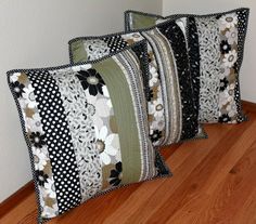 three decorative pillows sitting on top of a wooden floor