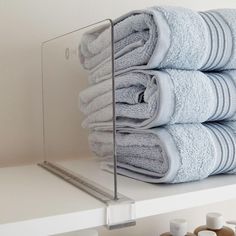 stack of folded towels sitting on top of a shelf