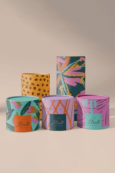 four different colored boxes with designs on them, one is pink and the other is blue