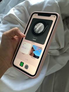 a person holding an iphone in their hand with pictures on the screen and buttons attached to it