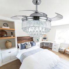 a bed room with a neatly made bed and a chandelier hanging from the ceiling