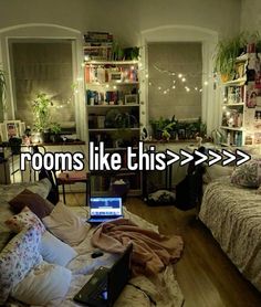 a bedroom with a laptop on the bed in front of it and lights strung from the ceiling