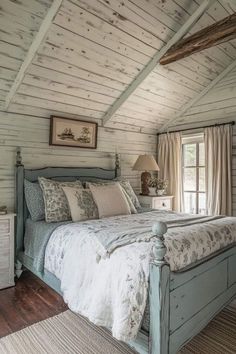 a bed sitting under a window in a bedroom next to a wooden floor and ceiling