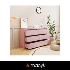 a pink dresser sitting in the middle of a living room next to a white clock