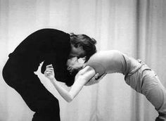 a man and woman dance in front of a curtain