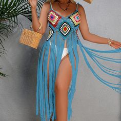 a woman wearing a straw hat and fringed skirt with her hand on her hip