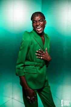 a woman in a green suit posing for a photo with her hands on her chest