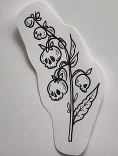 a piece of paper that has been drawn with black ink on white paper and is decorated with skulls and flowers