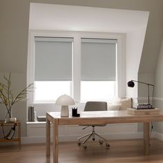 a room with two windows and a desk in it