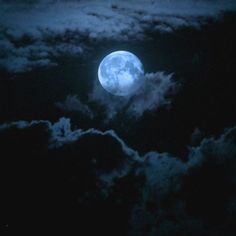 the full moon is shining brightly in the night sky above clouds and dark blue hues