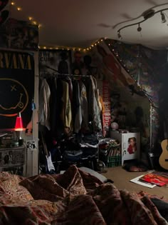 a bedroom with lots of clothes hanging on the wall and lights strung from the ceiling