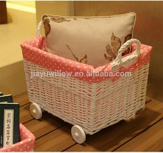 a white wicker basket with pink and white polka dots on the sides, sitting on a table next to a book