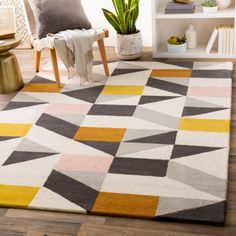 a living room area with a rug, chair and potted plant