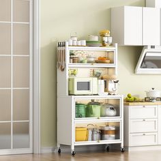 a kitchen with white cupboards and shelves filled with various dishes, appliances and utensils