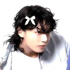 a man with black hair wearing a white shirt and a bow in it's hair