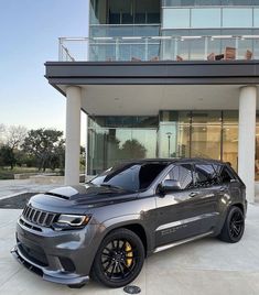 a grey jeep parked in front of a building