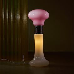 a pink lamp sitting on top of a wooden table