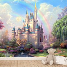 a teddy bear sitting in front of a castle wall mural with a rainbow painted on it