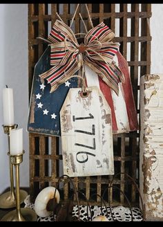 a patriotic sign with a bow hanging from it's side next to candles and other items