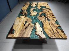 a table made out of wood with green and blue paint on it's surface