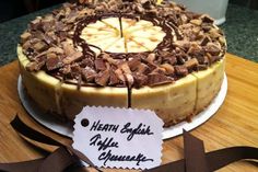 a cake with chocolate and banana slices on it sitting on a table next to a ribbon