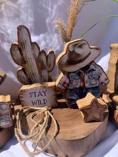 a wooden sign that says stay wild with cowboy hats on it and other items around it