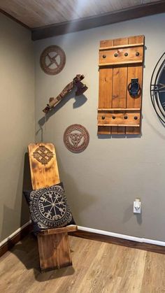 a wooden bench sitting in front of a wall with clocks on it