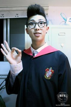 a young man wearing glasses and a harry potter shirt is making the vulcan sign with his hand