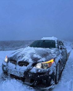 a car covered in snow parked on the side of a road