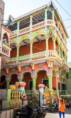 a woman standing in front of a colorful building