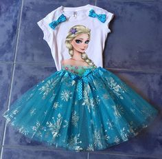 a frozen princess t - shirt and tutu skirt are laying on the tile floor