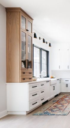 a kitchen with white cabinets and an area rug in front of the counter top that matches the cabinet doors