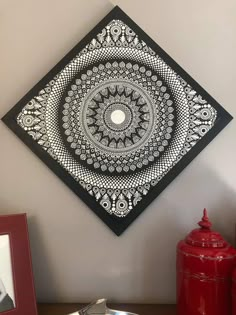 a black and white artwork hanging on the wall next to a red fire hydrant