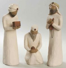 three ceramic figurines of men with bread and butter on their hands, one holding a book