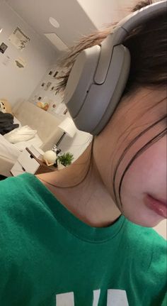 a girl with headphones on looking at the camera