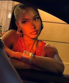 a woman sitting in the back seat of a car with her hand on the door handle