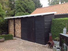 there is a black shed with wood in it