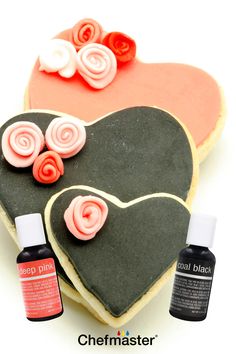 two heart shaped cookies with pink and orange icing