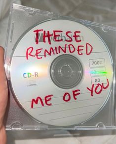 there is a cd with writing on it and someone holding the disc in their hand