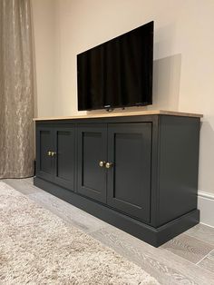 a flat screen tv sitting on top of a wooden cabinet