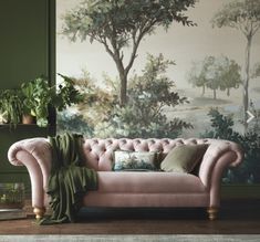 a pink couch sitting next to a green wall