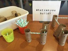 some toilet paper tubes and straws on a table with a sign that says, what can you build?