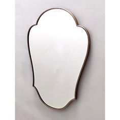 a white mirror sitting on top of a wall next to a black and gold frame