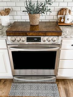 an oven with a potted plant on top of it in the middle of a kitchen