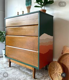 a wooden dresser sitting next to a potted plant